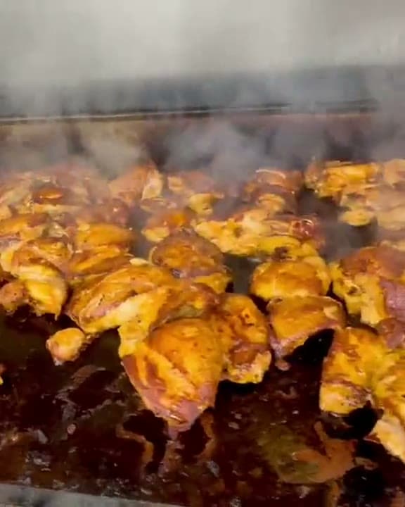 Marinated chicken sizzling and steaming on the Santa Fe flat-top grill